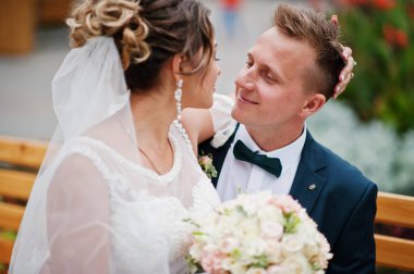 Parkta bir bankta oturmuş ve arıyorum bana yardımcı olanvarmı zarif Düğün çifti