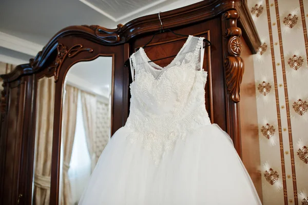 Свадебное платье висит на вешалке на шкафу в комнате . — стоковое фото