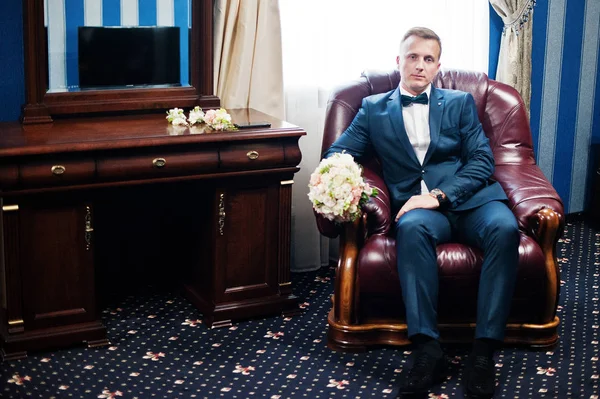 Portrait d'un beau marié posant avec bouquet nuptial dans son c — Photo