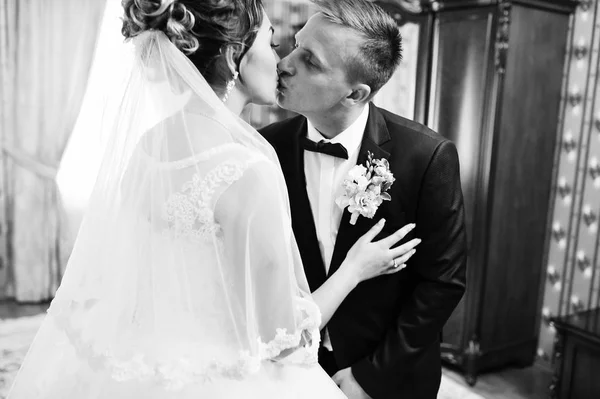 Pareja de bodas besándose en la habitación de una novia. Blanco y negro — Foto de Stock