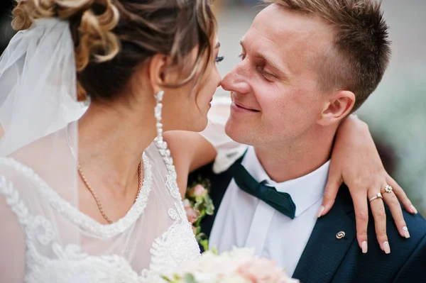 Casal de casamento elegante sentado em um banco no parque e olhar — Fotografia de Stock