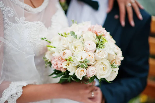 Close-up foto de uma noiva segurando um buquê de casamento em suas mãos — Fotografia de Stock