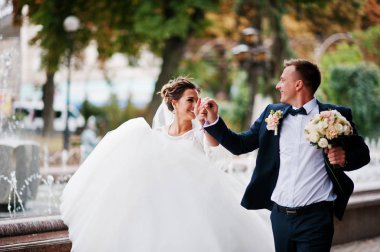 Düğün iki yürüyor ve gülümseyen kaldırımda bir çeşme ile ben