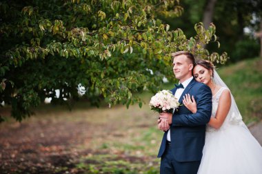 Yakışıklı yeni evli iki yürüyor ve her diğer zevk