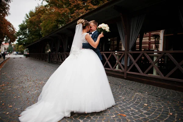 Romántica pareja de recién casados abrazándose en la calle de un —  Fotos de Stock