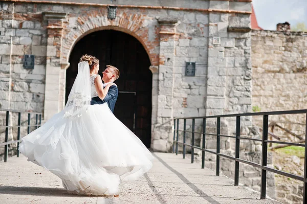 Pohledný ženich otáčí svou ženu na rukou vedle staré ga — Stock fotografie