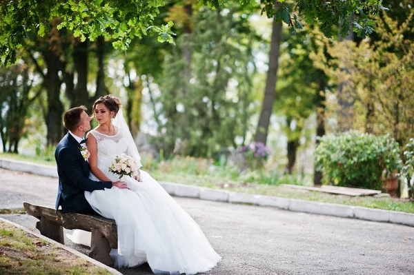 Outstanding bride sitting on her husband\'s lap during their wedd