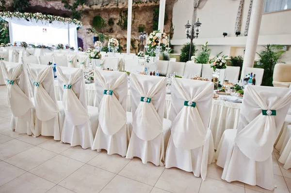 Elegant bröllop stolar dekorerade med grönt band. — Stockfoto