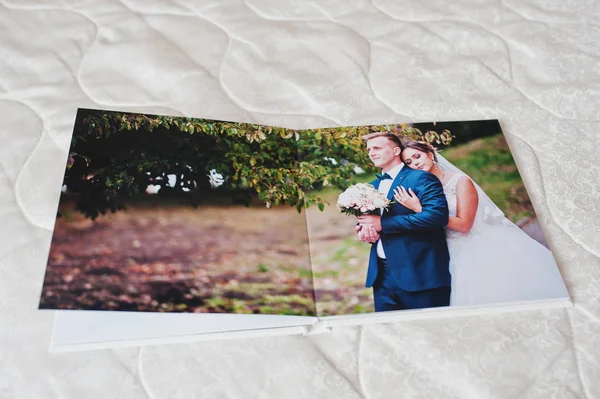 Oldalak esküvői fotókönyv vagy esküvői album a háttérben fehér kanapé — Stock Fotó
