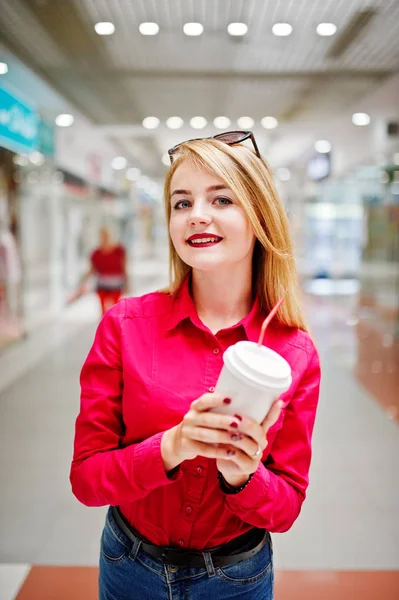 Portrait of a gorgeous woman in red blouse and jeans holding a c — Stock Photo, Image