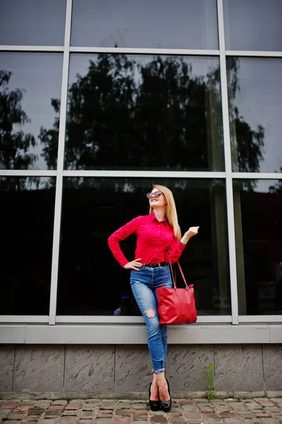 Porträtt av en utmärkt ung kvinna i röd blus och jeans posin — Stockfoto