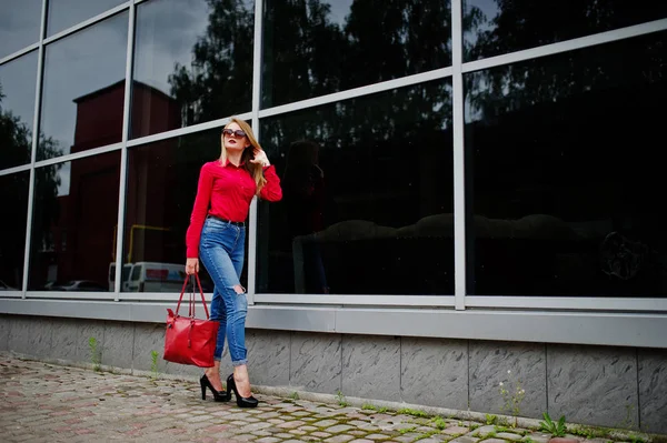 Porträtt av en utmärkt ung kvinna i röd blus och jeans posin — Stockfoto