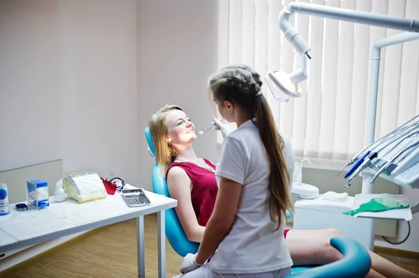 Attraktiva patienten i röd-violett klänning handpåläggning den dentala chai — Stockfoto