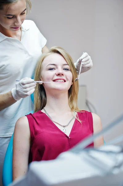 Прекрасная молодая женщина-дантист проверяет зубы своего пациента в — стоковое фото