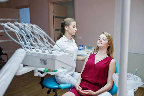 Hermosa dentista femenina posando y sonriendo con su encantadora pati — Foto de Stock