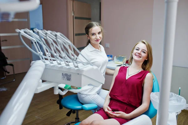 Beuatiful female dentist posing and smiling with her lovely pati