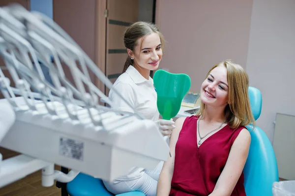Vackra tandläkare visar hennes patientens nya tänder genom mi — Stockfoto