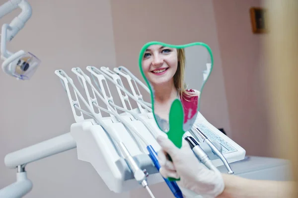 Bella dentista mostrando i nuovi denti del suo paziente attraverso il mi — Foto Stock