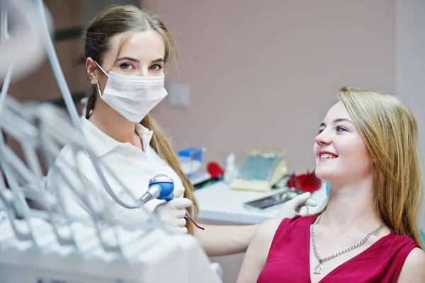 Attraktiva patienten i röd-violett klänning handpåläggning den dentala chai — Stockfoto