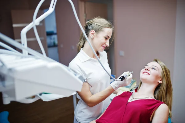 Paziente attraente in abito rosso-viola che posa sul chai dentale — Foto Stock