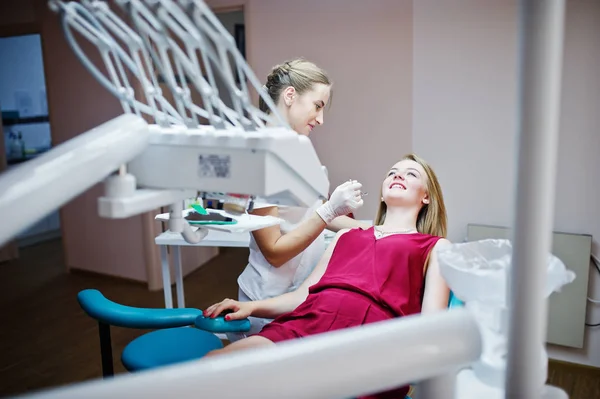 Paziente attraente in abito rosso-viola che posa sul chai dentale — Foto Stock