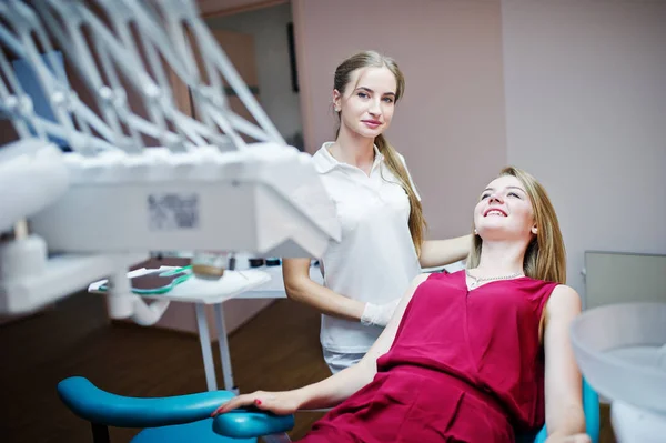 Beuatiful female dentist posing and smiling with her lovely pati — Stock Photo, Image