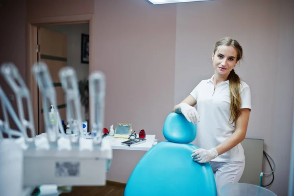 Good-looking female dentist posing in white coat in a modern wel — Stock Photo, Image