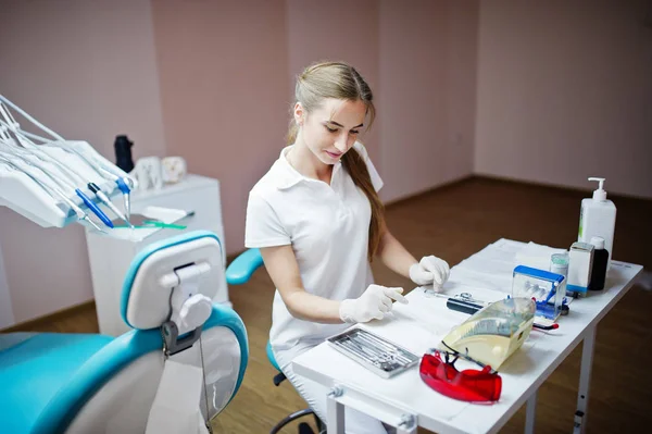 Dentista guapa posando con algunos instrumentos dentales — Foto de Stock