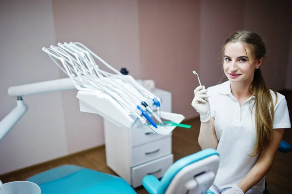 Gut aussehende Zahnärztin posiert mit einigen zahnärztlichen Instrumenten — Stockfoto