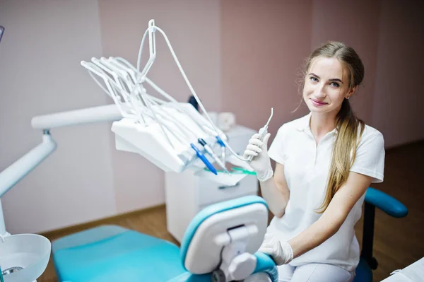 Gut aussehende Zahnärztin posiert mit einigen zahnärztlichen Instrumenten — Stockfoto