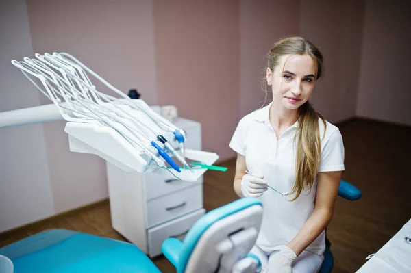 İyi görünümlü kadın dişçi diş enstrümanlar ile poz — Stok fotoğraf