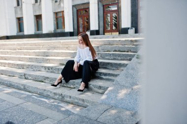 Yakışıklı genç kadın beyaz bluz, geniş siyah pantolon ve b