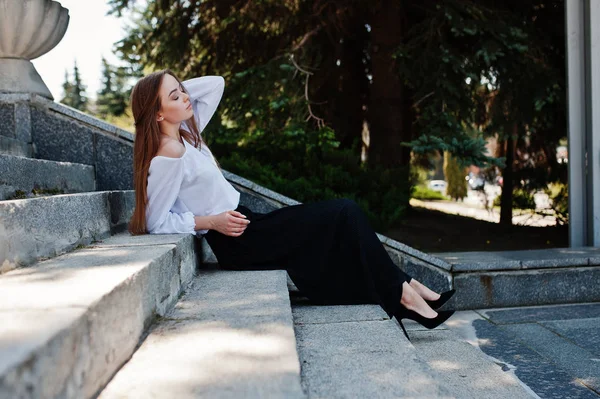 Mujer joven atractiva en blusa blanca, pantalones negros anchos y b —  Fotos de Stock