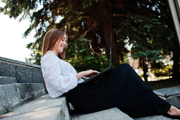 Yakışıklı genç kadın beyaz bluz, geniş siyah pantolon ve b