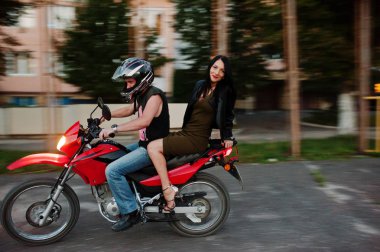 Kadın başka bir ile bir motosiklet sürme elbise ve deri ceketli
