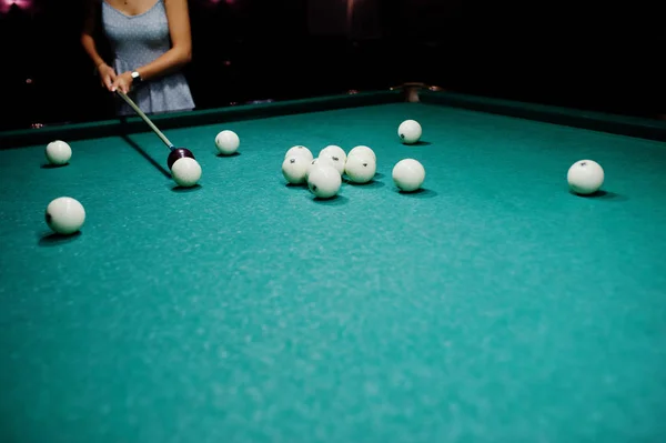 Mujer en vestido jugando al billar con un hombre en un pub . — Foto de Stock