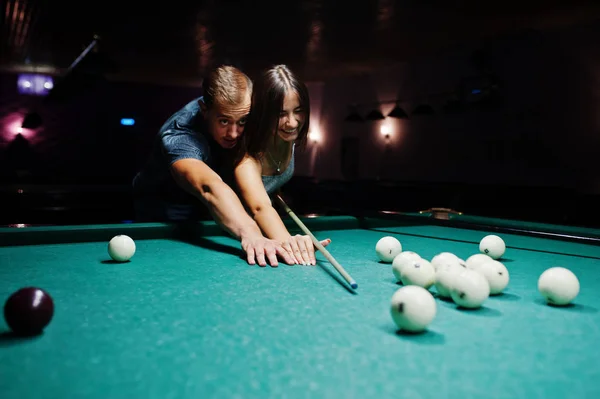 Mulher de vestido jogando bilhar com um homem em um pub . — Fotografia de Stock