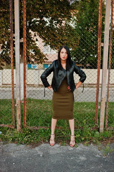 Muhteşem kadın elbise ve deri ceket yanında ayakta 