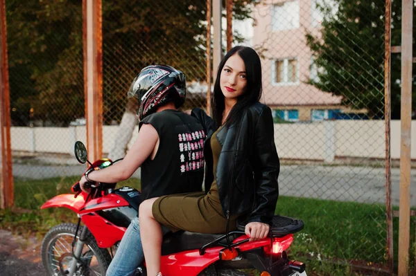 Mujer en vestido y chaqueta de cuero montando una moto con el ánodo —  Fotos de Stock