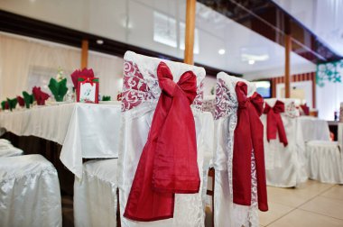 Sandalye kırmızı yay ile düğün üzerlerine restoranda bağlı.