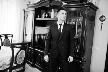 Portrait of a handsome groom posing on his own in the room on a 