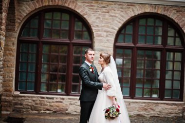 İki muhteşem düğün yürüyor ve eski yapı yanında poz