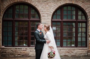 İki muhteşem düğün yürüyor ve eski yapı yanında poz