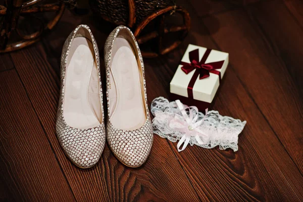 Foto de cerca de zapatos de boda, ligas y caja pequeña con ri rojo — Foto de Stock