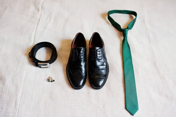 Close-up photo of groom's black shoes, belt, golden cufflinks an — Stock Photo, Image