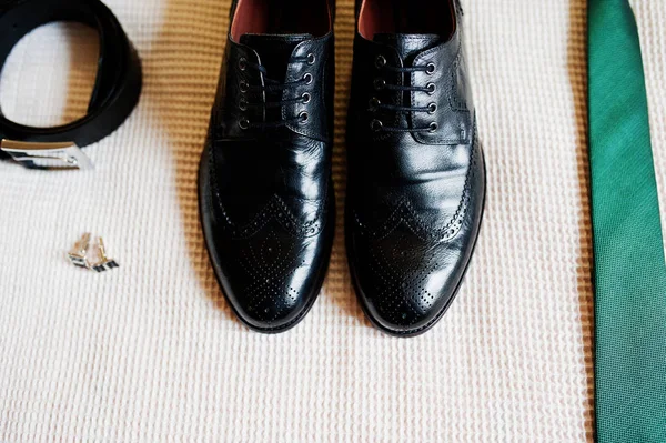 Close-up photo of groom's black shoes, belt, golden cufflinks an — Stock Photo, Image