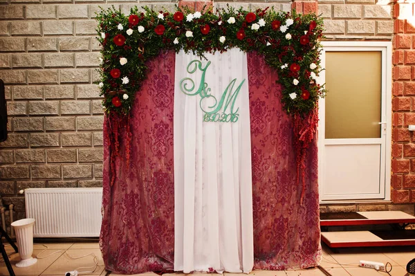 Arco de casamento floral com iniciais do casal e cortinas roxas o — Fotografia de Stock