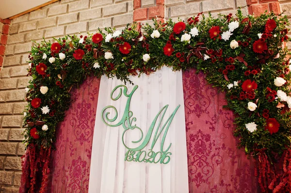Arco da sposa floreale con iniziali di coppia e tende viola o — Foto Stock