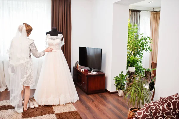 Retrato de una novia en camisón posando con su vestido de novia i — Foto de Stock
