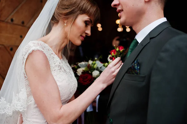 Bella sposa pinning un fiore asola fino al jack di uno sposo — Foto Stock